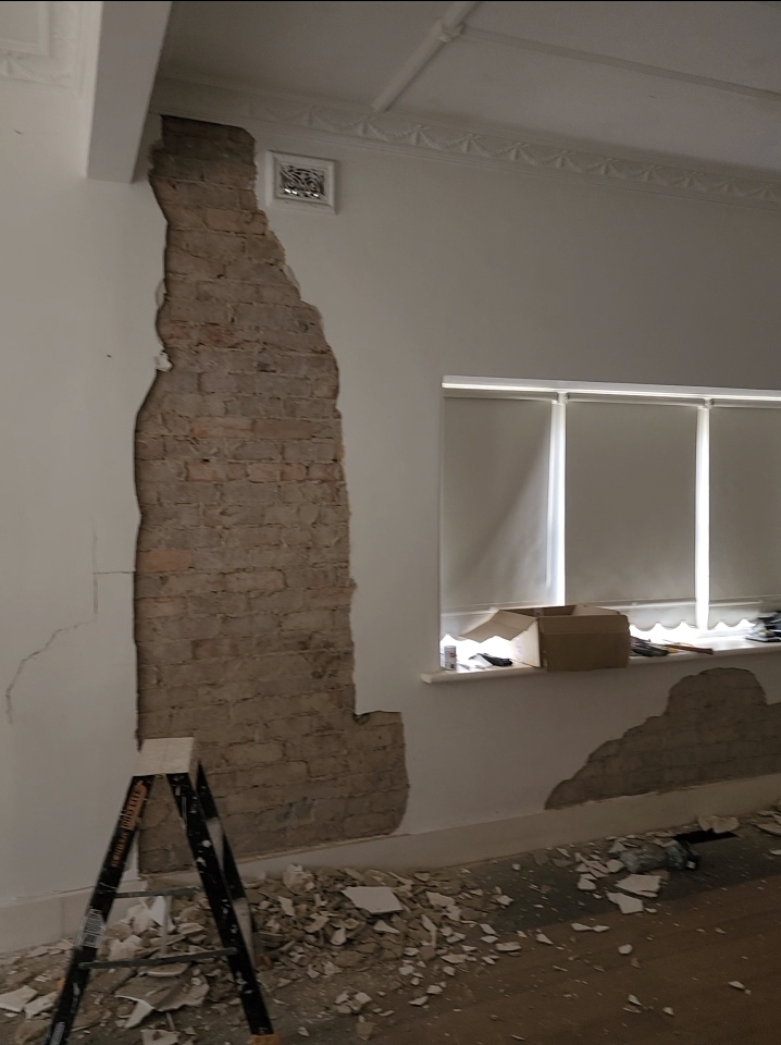 Period Brighton room with damaged plaster removed before repainting